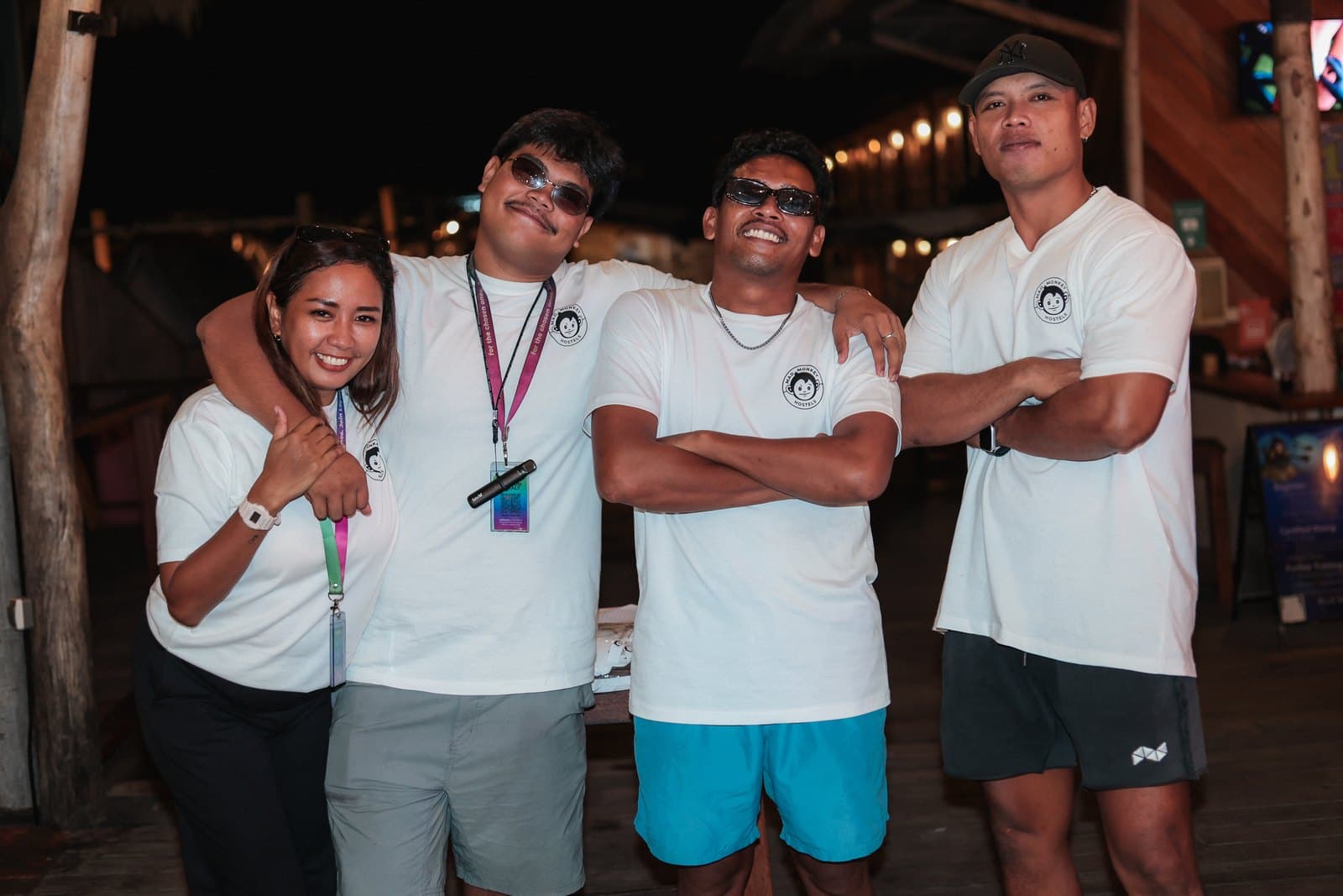 Four Mad Monkey team members together at the hostel bar