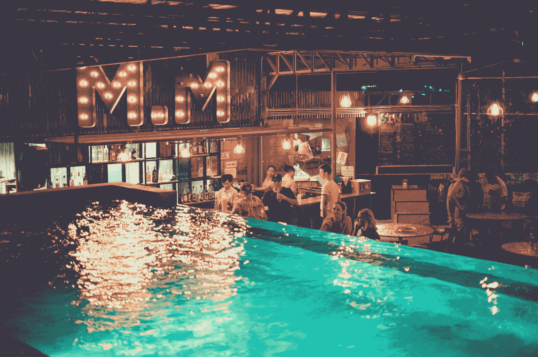 The lit poolside bar at a Mad Monkey hostel after dark